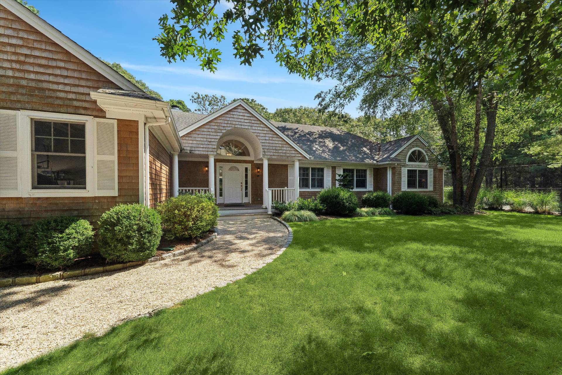 18 Old Fields Lane Quogue, NY 11959 - Photo 2 of 34 a front view of a house with a garden