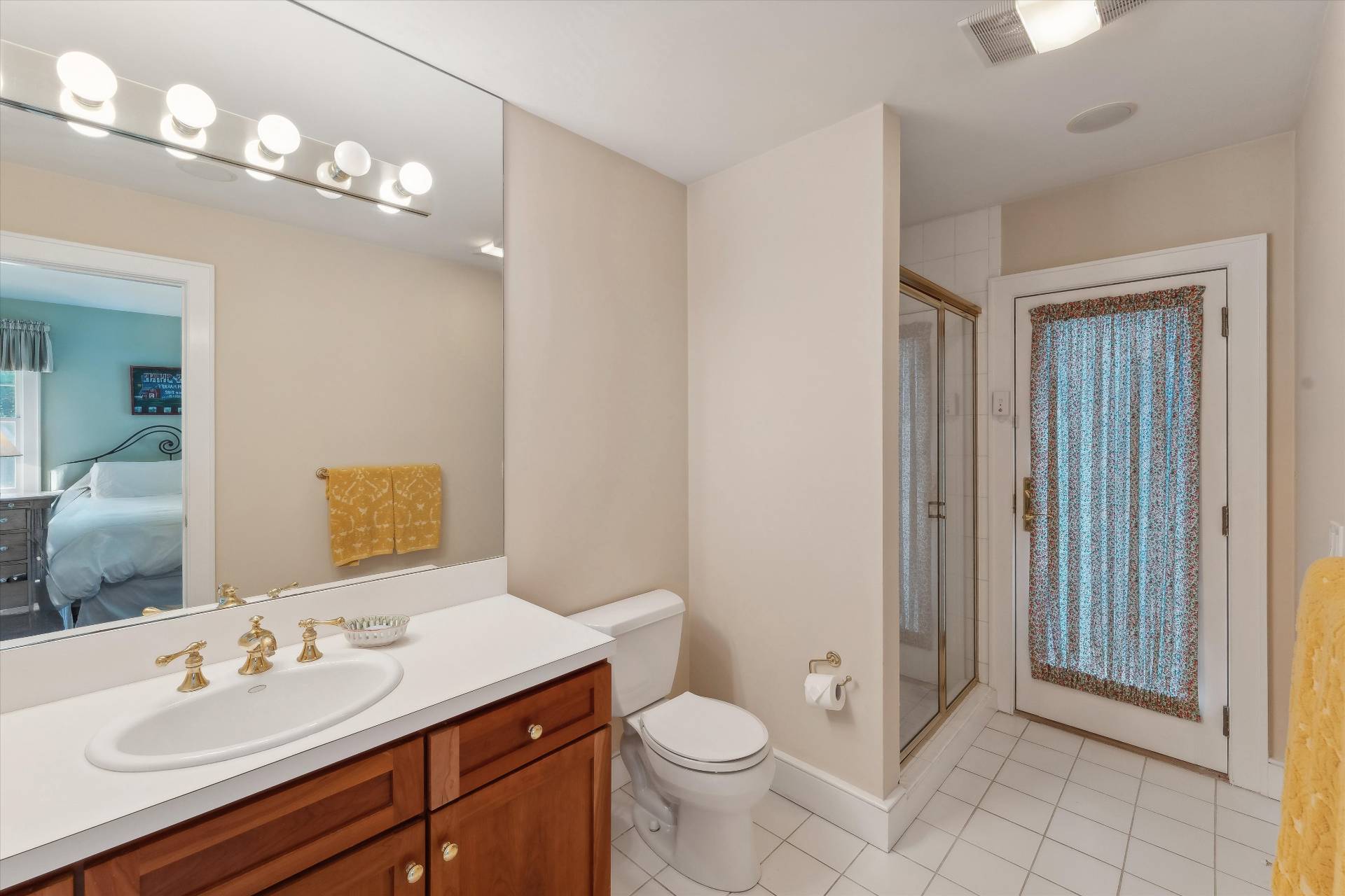 18 Old Fields Lane Quogue, NY 11959 - Photo 22 of 34 a bathroom with a toilet a sink a light fixture and a mirror
