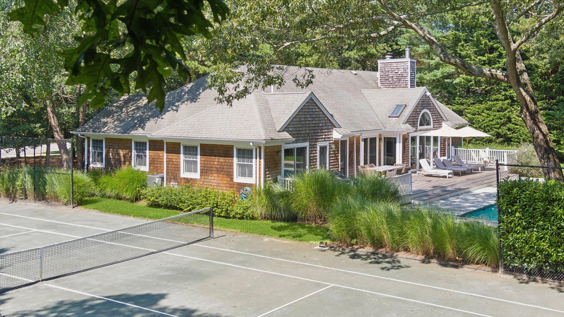 18 Old Fields Lane Quogue, NY 11959 - Photo 4 of 34 a front view of a house with a garden