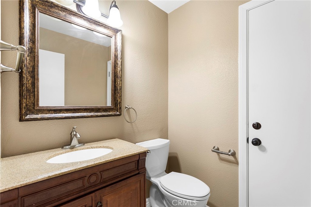 2881 Todd Street Oceanside, CA 92054 - Photo 16 of 41 a bathroom with a granite countertop sink vanity mirror and toilet