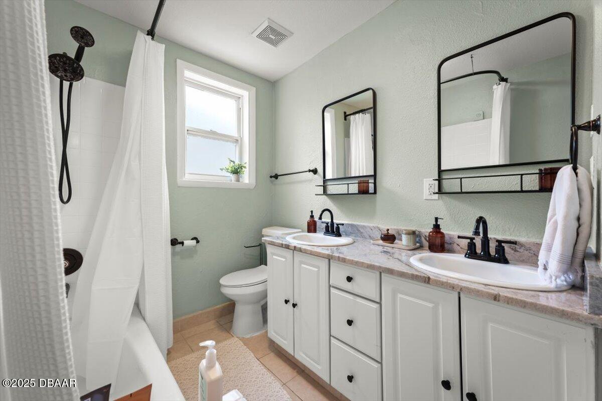 2057 Huntsford Road Jacksonville, FL 32207 - Photo 4 of 30 a bathroom with a double vanity sink toilet and a mirror