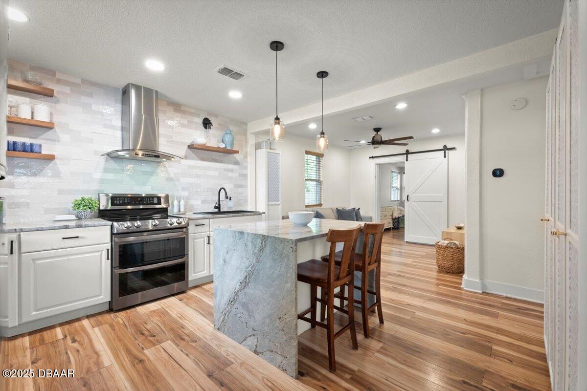 2057 Huntsford Road Jacksonville, FL 32207 - Photo 5 of 30 a kitchen with stainless steel appliances kitchen island granite countertop a stove a sink a refrigerator and a dining table with wooden floor