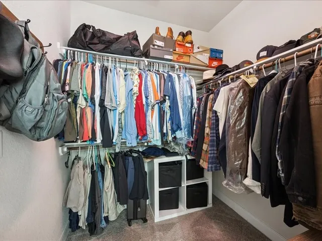 a view of walk in closet with clothes