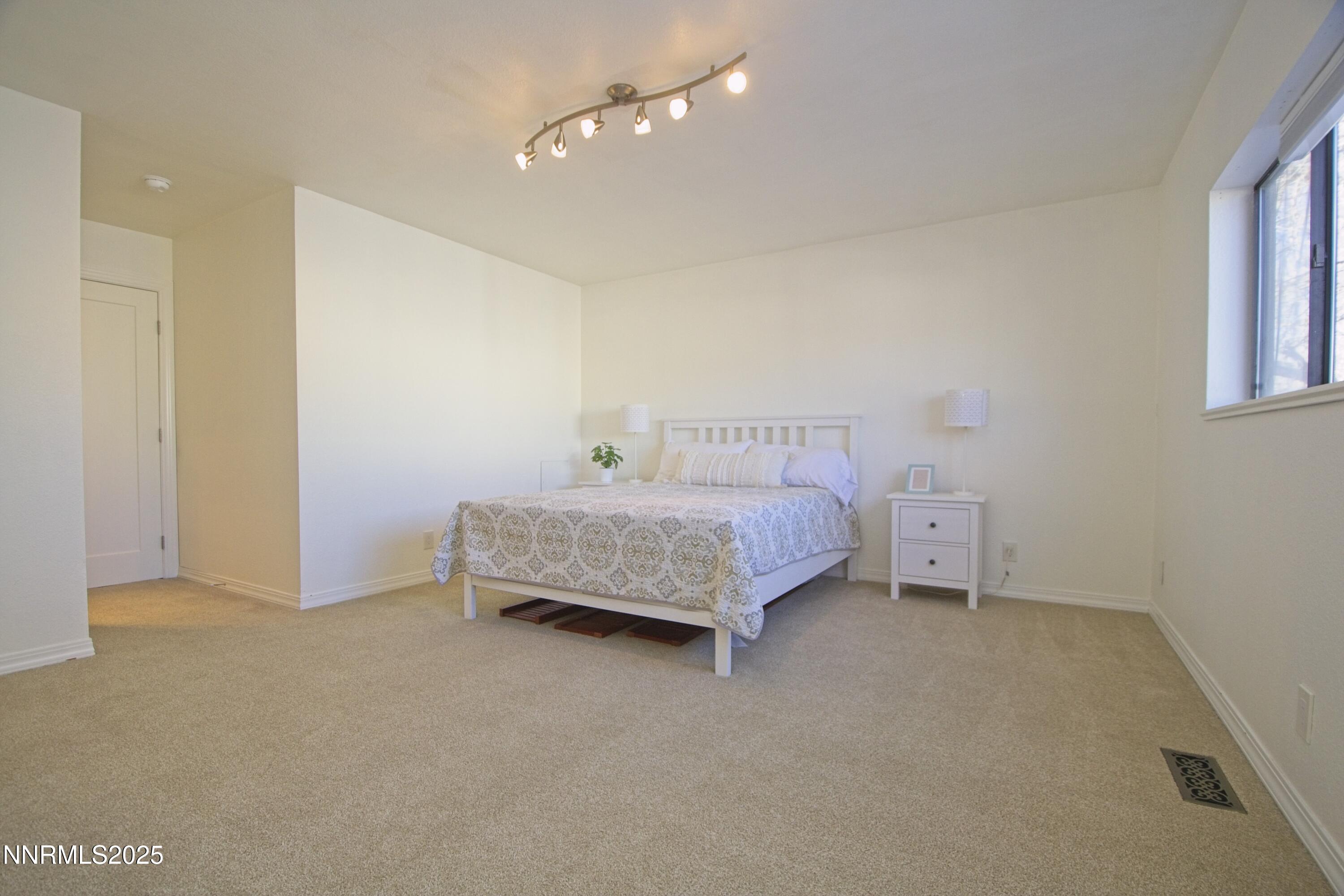 125 Mary Street, Unit A Reno, NV 89509 - Photo 12 of 22 a bedroom with a bed and a chandelier