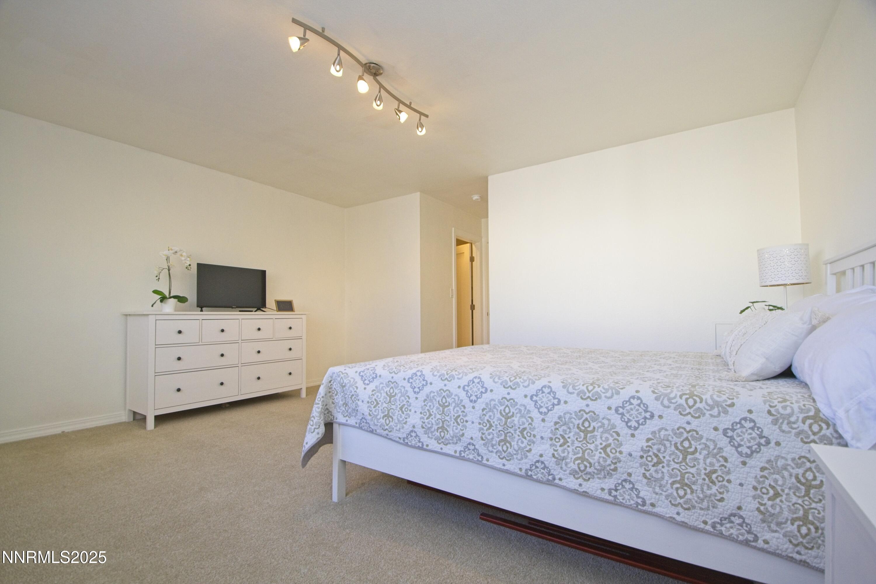 125 Mary Street, Unit A Reno, NV 89509 - Photo 14 of 22 a bedroom with a bed and a flat screen tv