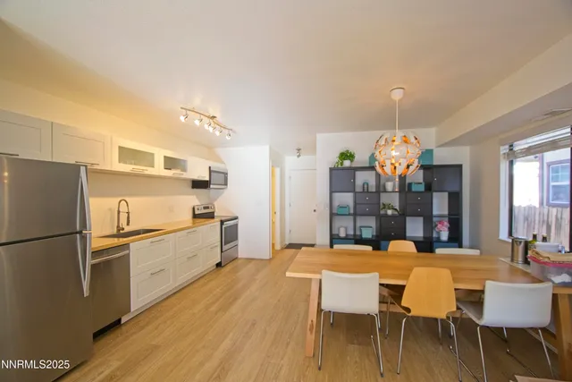a kitchen with a table chairs refrigerator and microwave