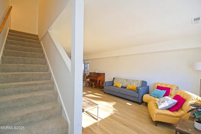 a living room with furniture and stairs