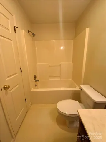 a bathroom with a toilet and a bath tub