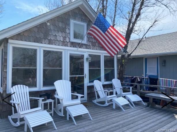 151 Ocean Road Ocean Beach, NY 11770 - Photo 2 of 19 a balcony with furniture and wooden floor