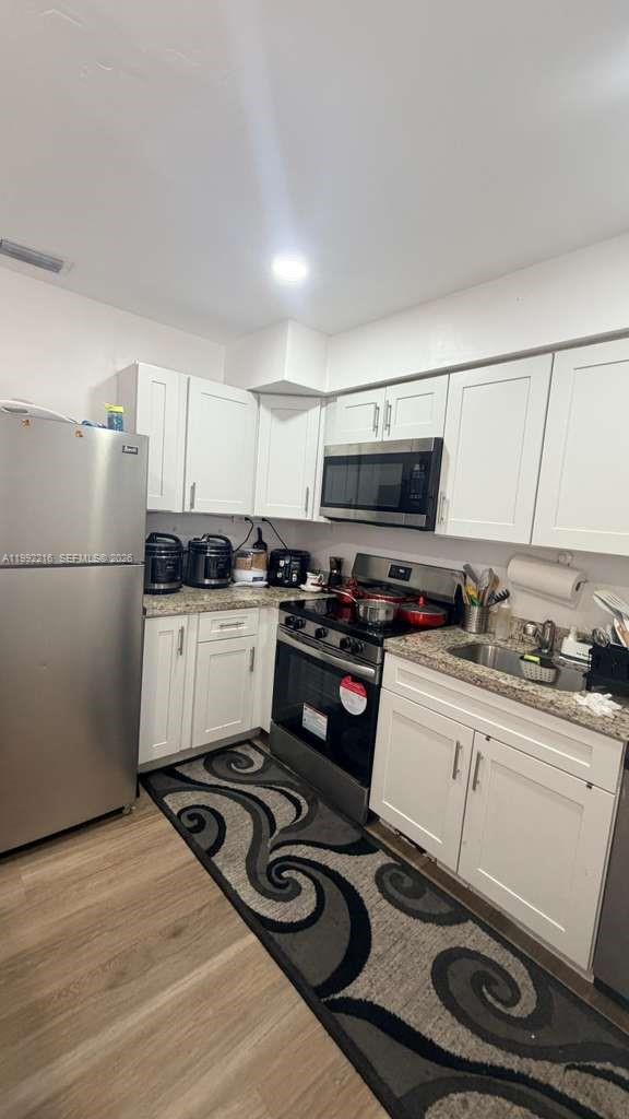 673 West 30th Street, Unit 671 Hialeah, FL 33012 - Photo 13 of 19 a kitchen with a stove a sink and a refrigerator