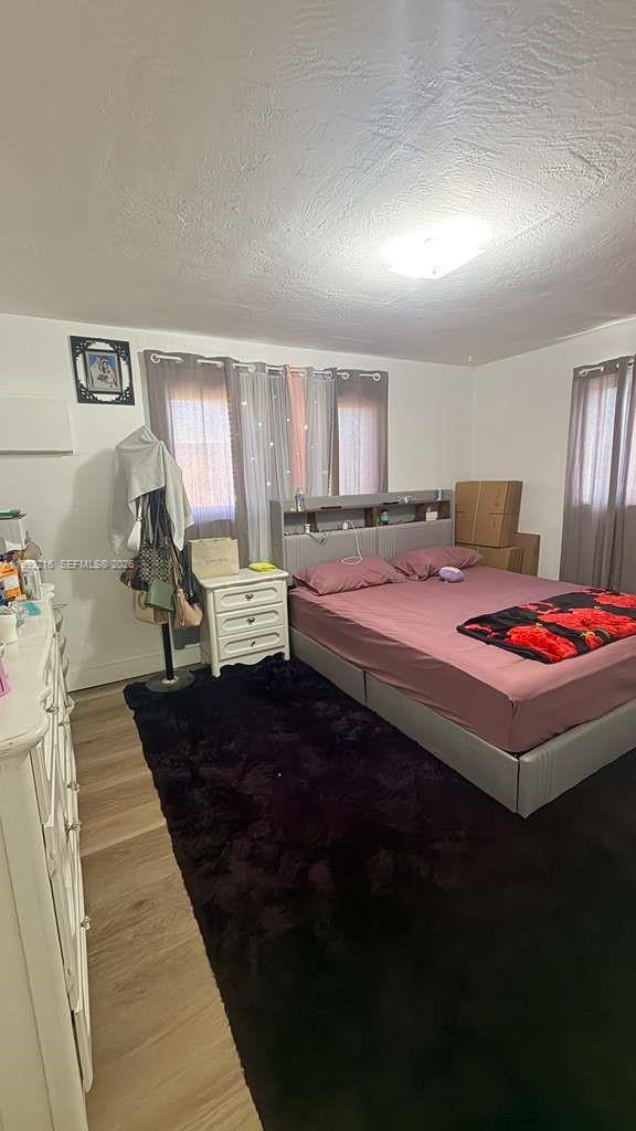 673 West 30th Street, Unit 671 Hialeah, FL 33012 - Photo 19 of 19 a bedroom with a bed wooden floor and window