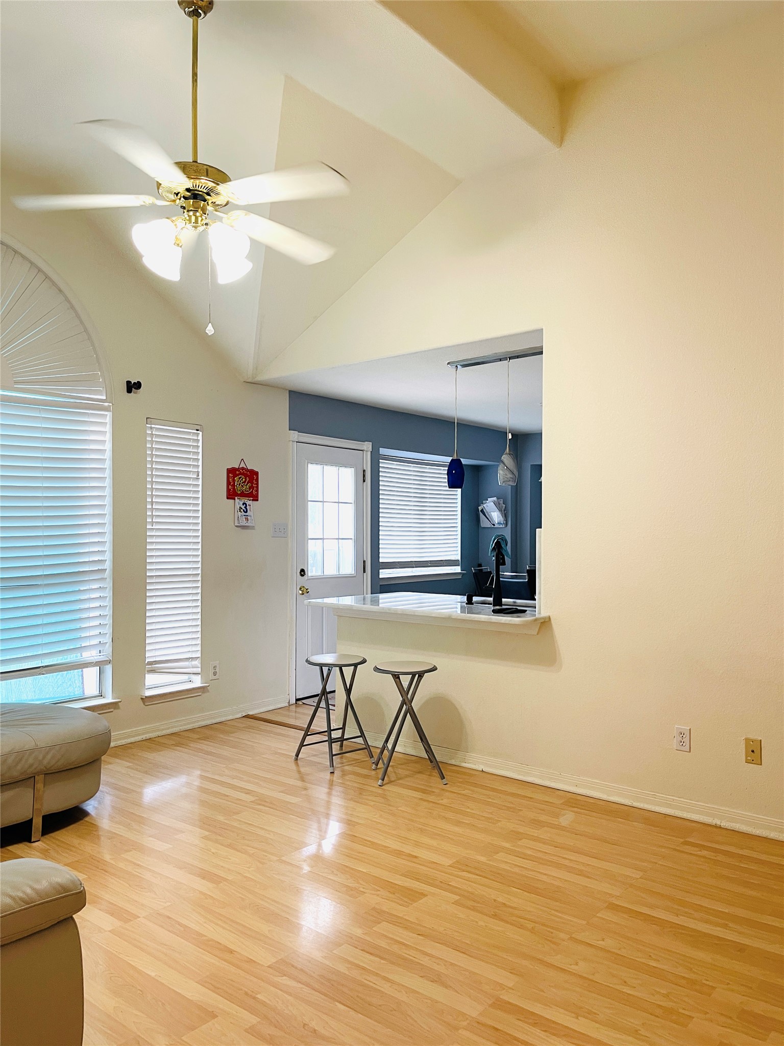 814 Broken Feather Trail Pflugerville, TX 78660 - Photo 5 of 24 A living space with high vaulted ceilings and light-colored hardwood flooring, offering an open view into the kitchen area.