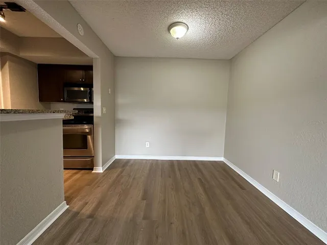 an empty room with wooden floor closet and windows