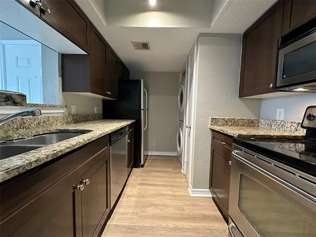 a kitchen with granite countertop stainless steel appliances and wooden cabinets