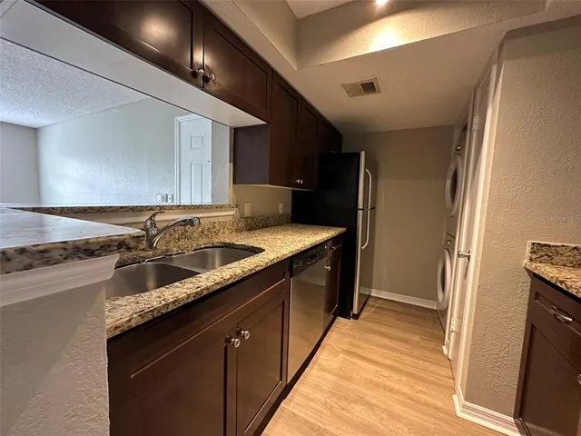 a kitchen with granite countertop a sink and cabinets