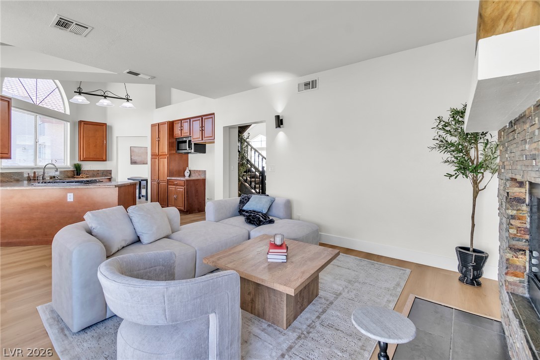 370 Rushing Creek Court Henderson, NV 89014 - Photo 8 of 32 Gleaming hardwood floors and a stone fireplace anchor this airy open concept layout.