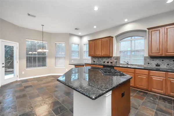 a large kitchen with stainless steel appliances granite countertop a stove a sink and a granite counter tops