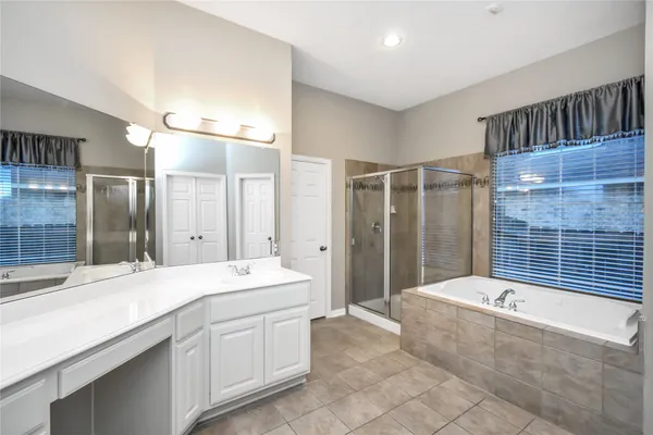 a bathroom with a tub sink and mirror