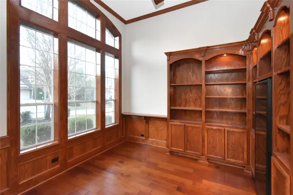 a area with wooden floor and windows