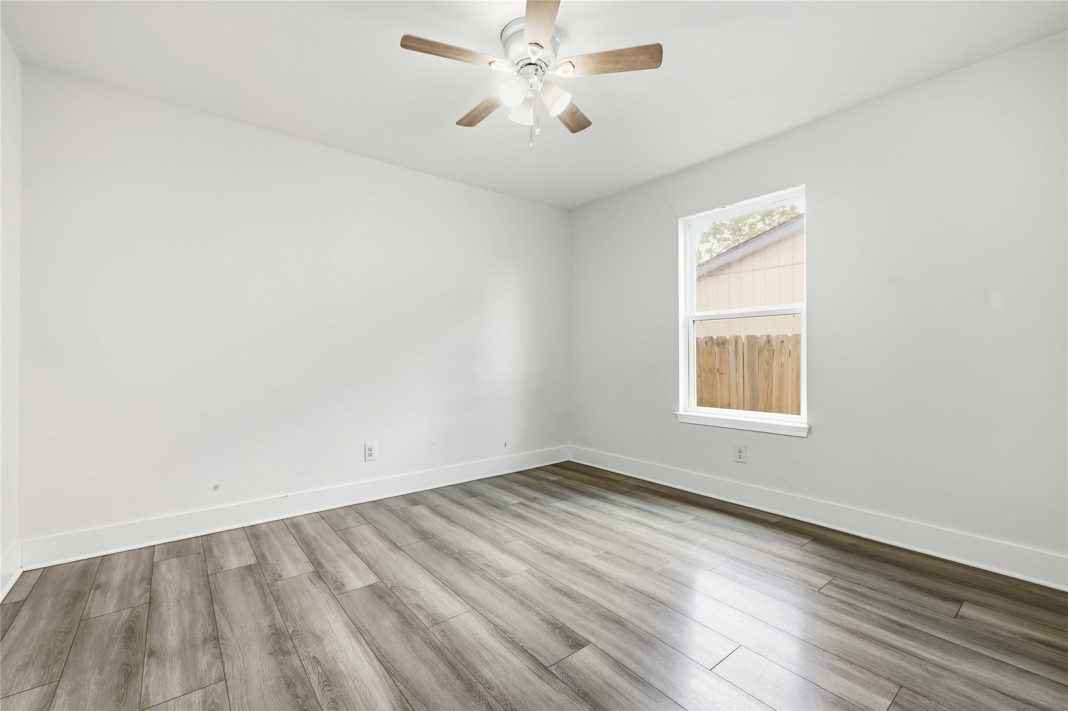 400 Booth Street Taylor, TX 76574 - Photo 26 of 35 Unfurnished room with light wood-type flooring and a ceiling fan