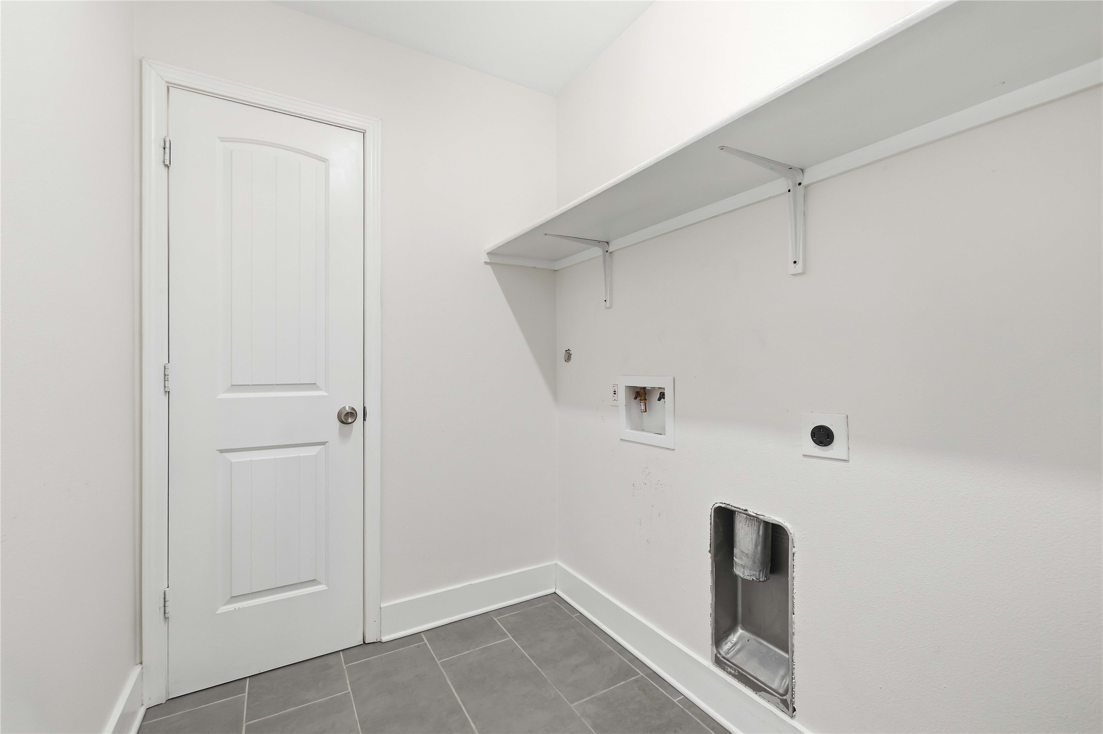 400 Booth Street Taylor, TX 76574 - Photo 28 of 35 Laundry area with washer hookup, dark tile patterned flooring, and electric dryer hookup