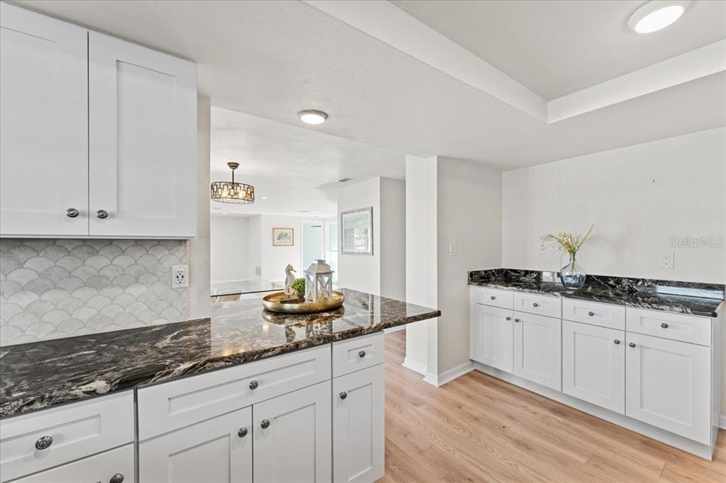 5028 Ensign Loop New Port Richey, FL 34652 - Photo 20 of 76 a kitchen with granite countertop white cabinets and white appliances