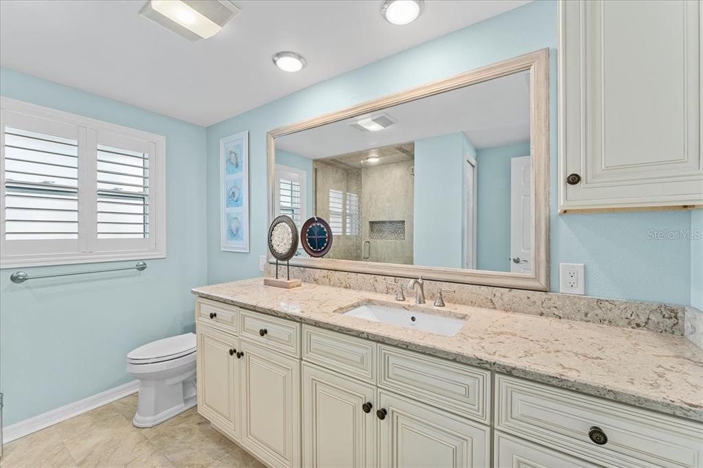 5028 Ensign Loop New Port Richey, FL 34652 - Photo 25 of 76 a bathroom with a granite countertop sink a toilet and a mirror