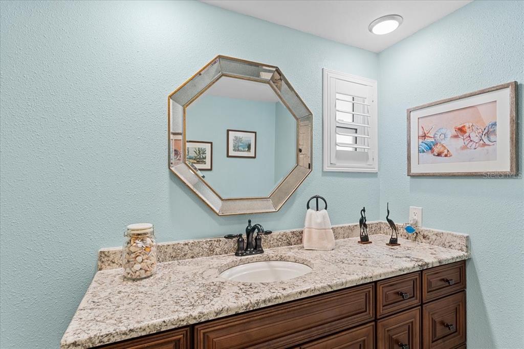 5028 Ensign Loop New Port Richey, FL 34652 - Photo 30 of 76 a bathroom with a granite countertop sink and a mirror