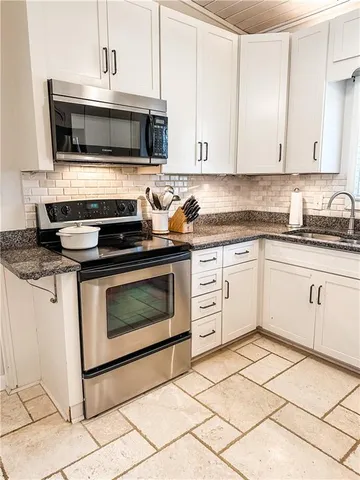 a kitchen with cabinets stainless steel appliances and a sink