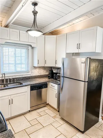 a kitchen with granite countertop white cabinets and white appliances