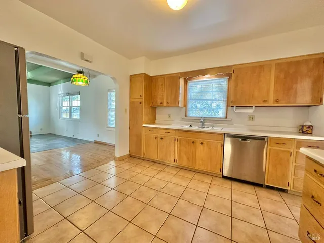 a view of an entryway with wooden floor and a kitchen space