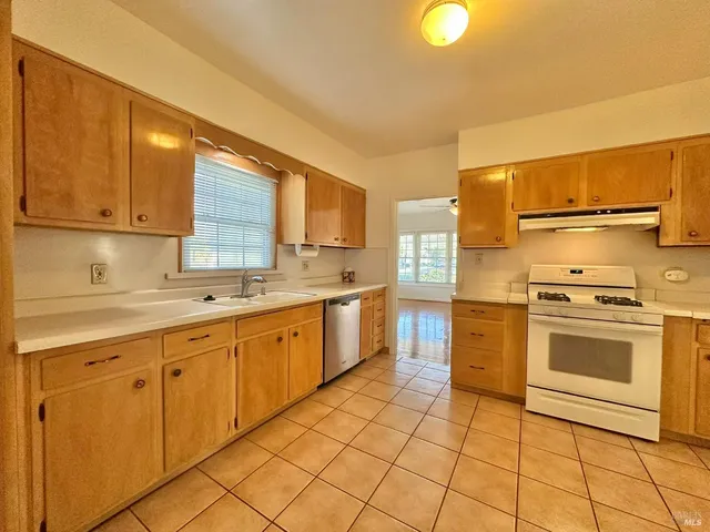 a view of a kitchen with wooden cabinet and a refrigerator