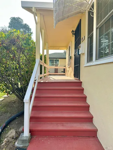 an empty room with wooden floor a fireplace a ceiling fan and windows