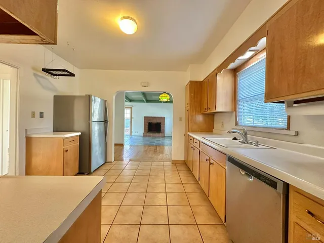 a kitchen with stainless steel appliances a refrigerator sink stove and cabinets
