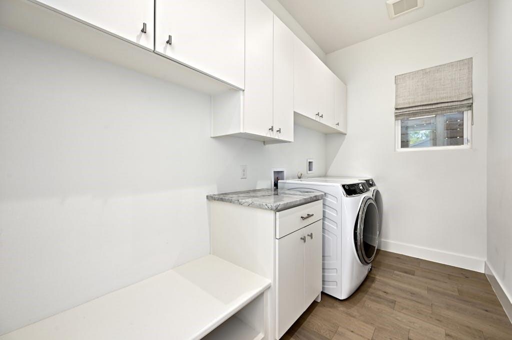 5212 Huisache Street, Unit 2 Austin, TX 78751 - Photo 27 of 30 Laundry area with dark wood-style floors, cabinet space, and independent washer and dryer