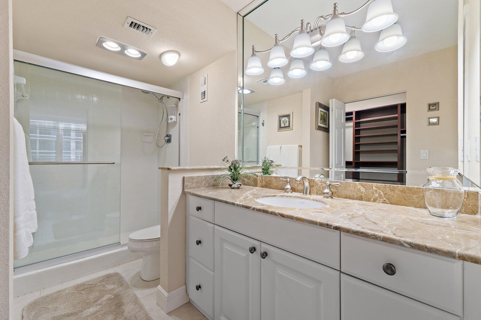 Undisclosed Address Singer Island, FL 33404 - Photo 25 of 77 a bathroom with a granite countertop double vanity sink a mirror and a shower