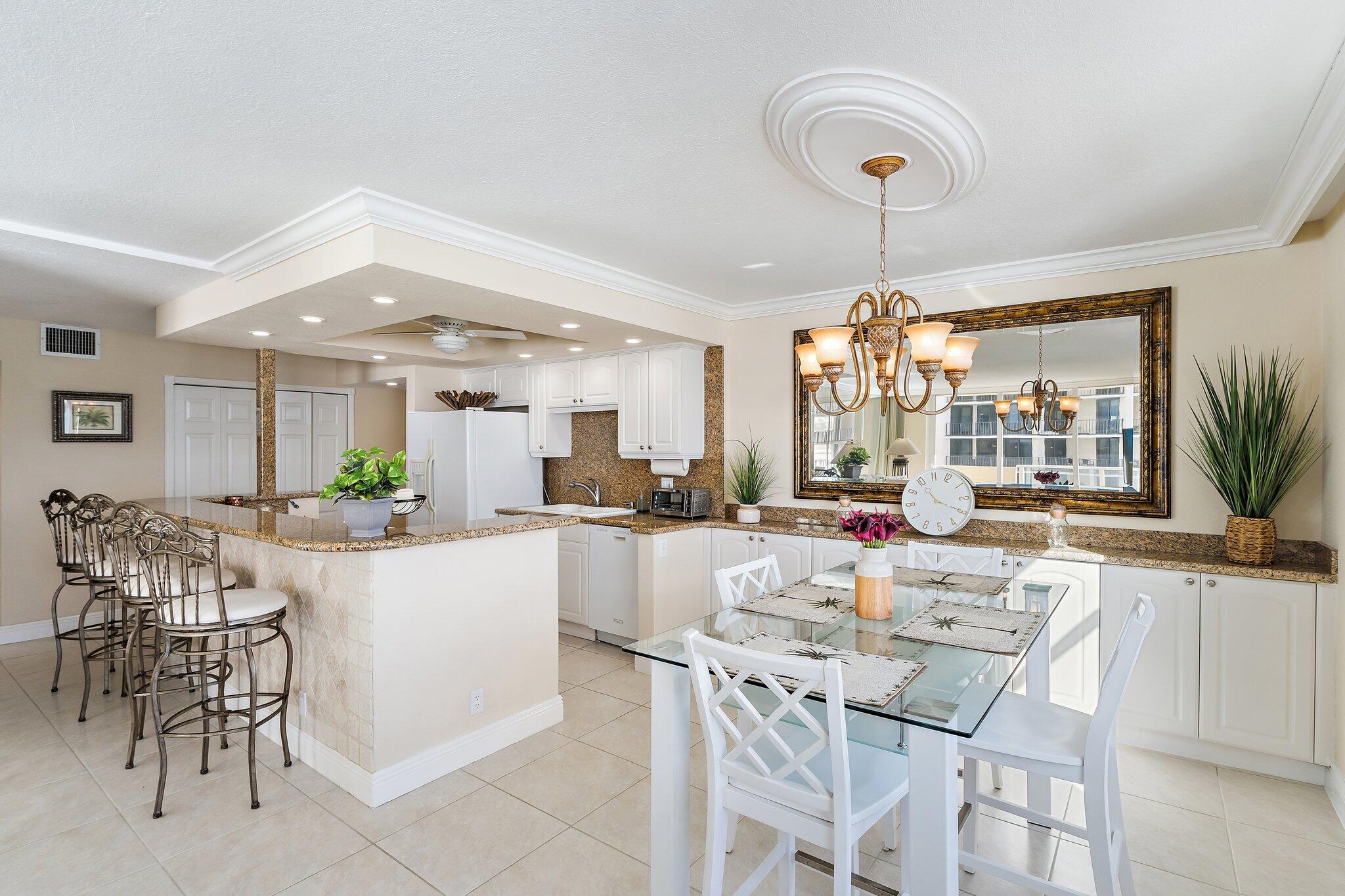 Undisclosed Address Singer Island, FL 33404 - Photo 34 of 77 a kitchen with a dining table chairs and white cabinets