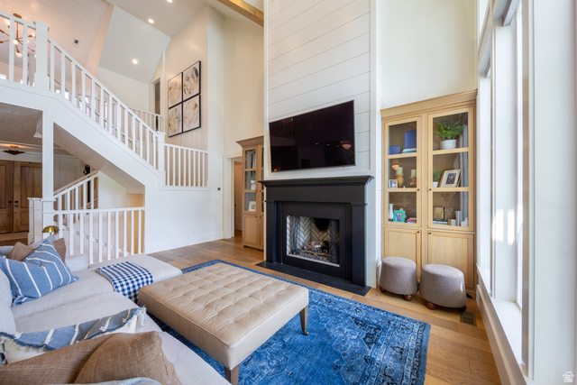 630 East Center Street Alpine, UT 84004 - Photo 40 of 115 Spacious living area featuring a two-story shiplap fireplace surround with a black mantel, recessed lighting, and built-in cabinetry with glass doors