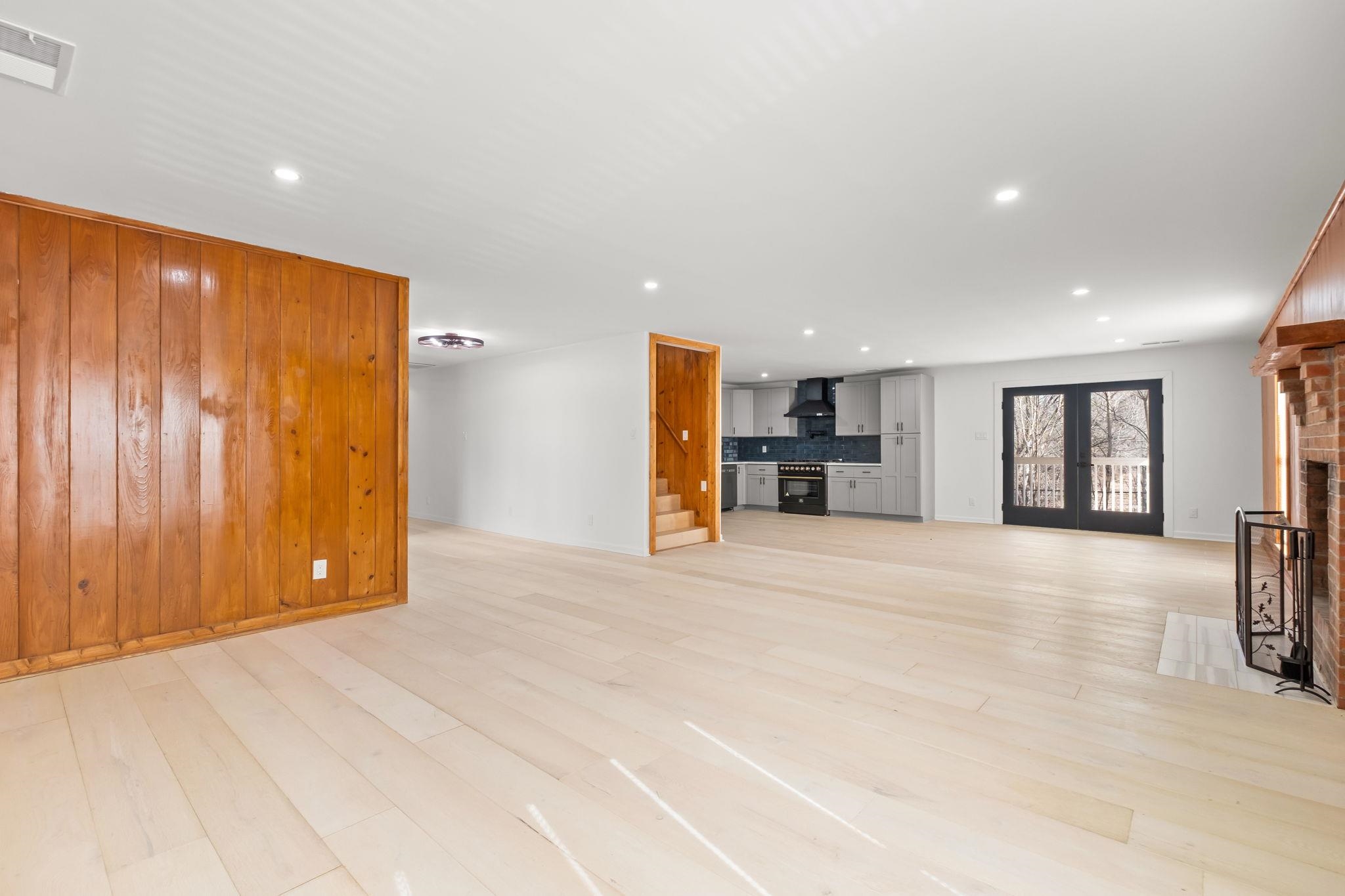 6224 Benjestown Road Memphis, TN 38127 - Photo 10 of 39 Unfurnished living room with light wood-style flooring, recessed lighting, a fireplace, and wooden walls