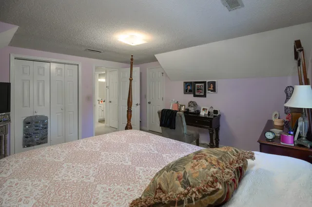 a bedroom with a bed dresser and a large mirror