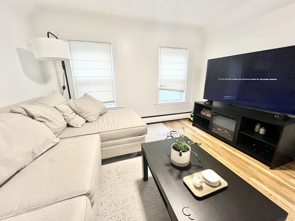 10-12 Edith Avenue, Unit 3 Everett, MA 02149 - Photo 7 of 21 a living room with furniture and a flat screen tv