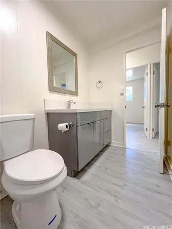 a bathroom with a toilet a sink and mirror
