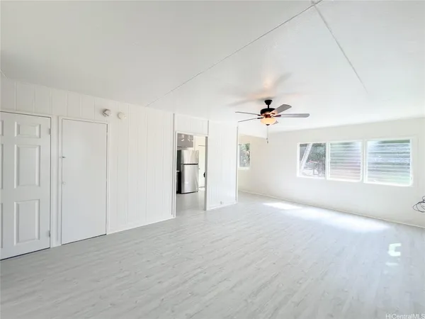 a view of a livingroom with a ceiling fan window and hardwood floor