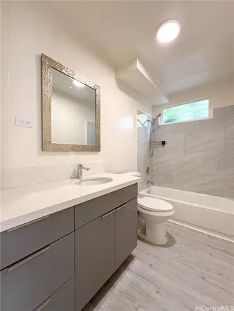 a bathroom with a toilet sink a mirror and vanity