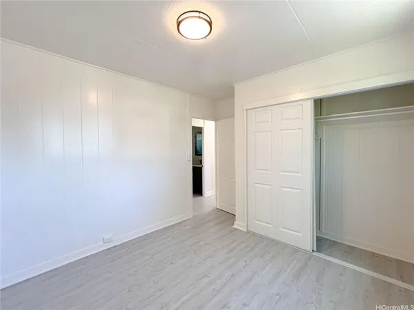 an empty room with wooden floor and closet