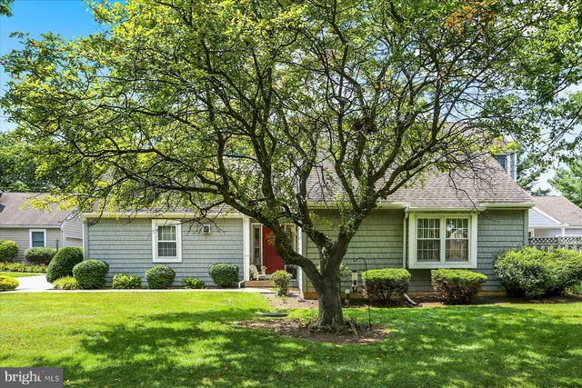 a front view of a house with a garden and yard