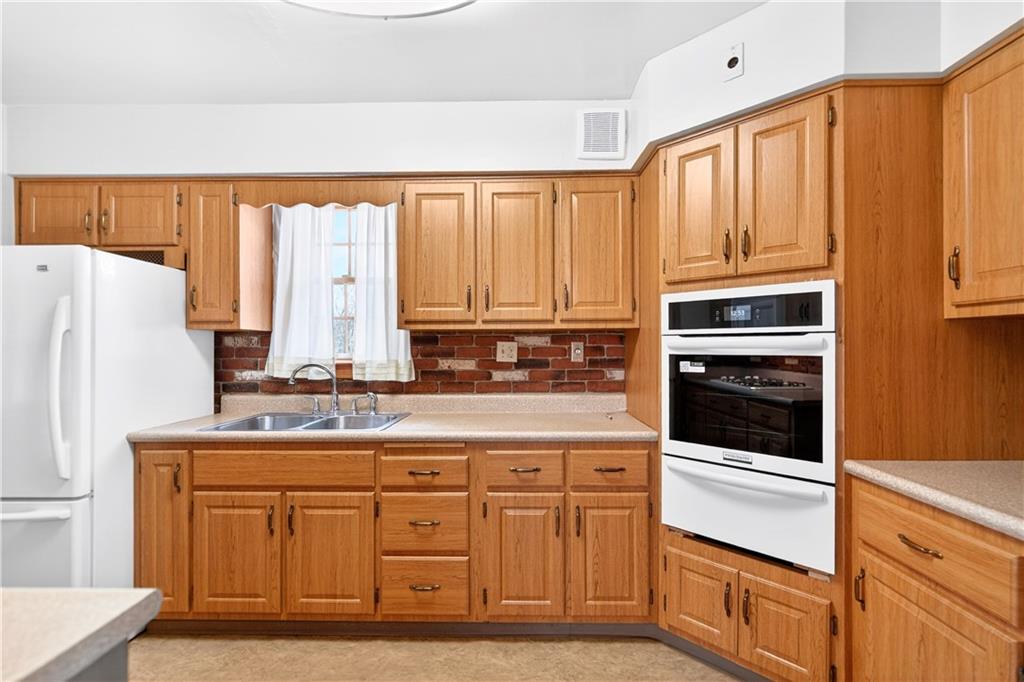 1008 Schweitzer Road McKeesport, PA 15135 - Photo 22 of 43 a kitchen with stainless steel appliances white cabinets and a refrigerator
