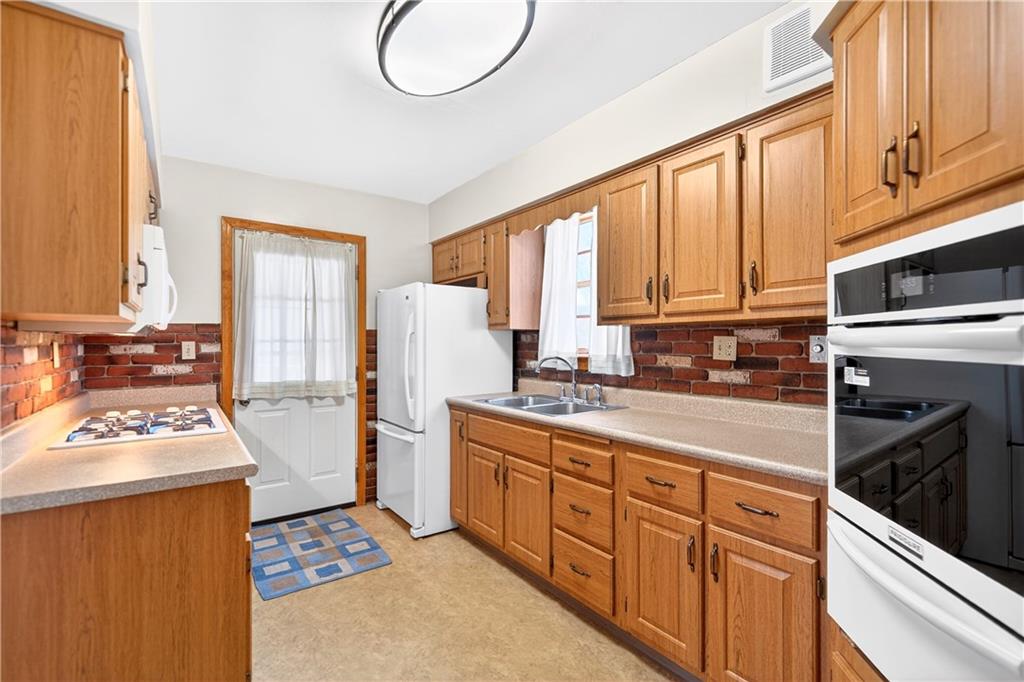 1008 Schweitzer Road McKeesport, PA 15135 - Photo 23 of 43 a kitchen with stainless steel appliances kitchen island granite countertop a refrigerator stove top oven and sink