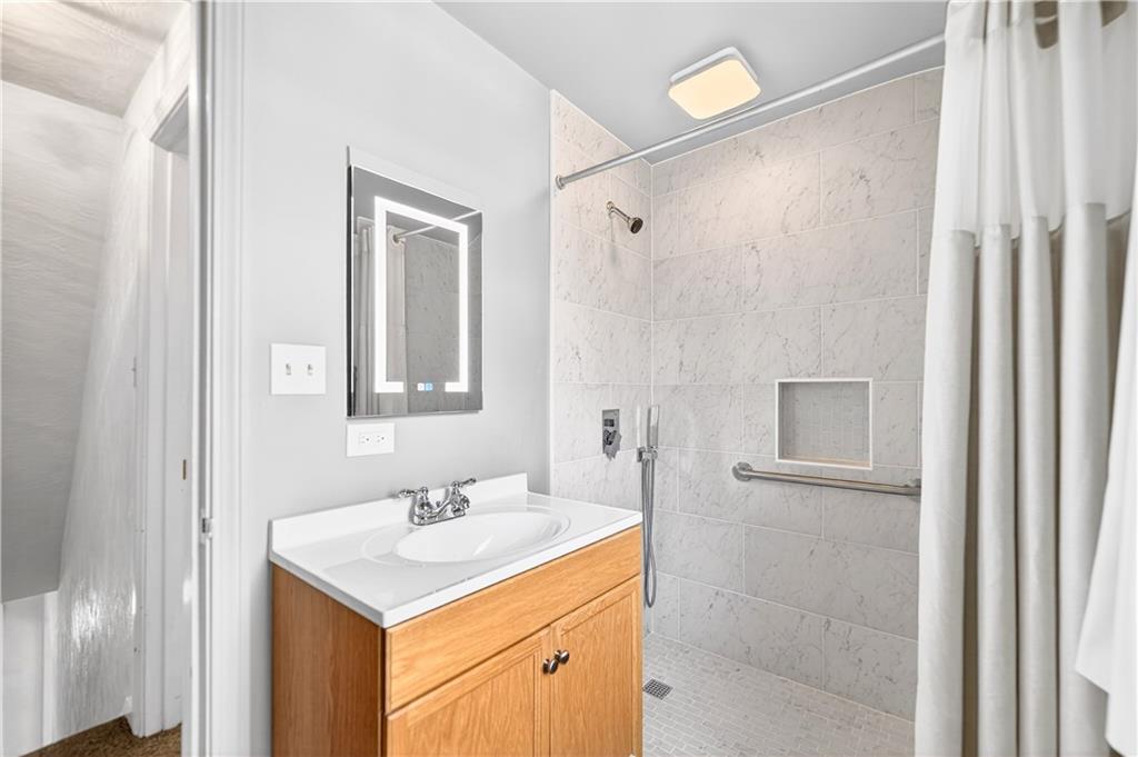1008 Schweitzer Road McKeesport, PA 15135 - Photo 33 of 43 a bathroom with a granite countertop sink a mirror and a shower