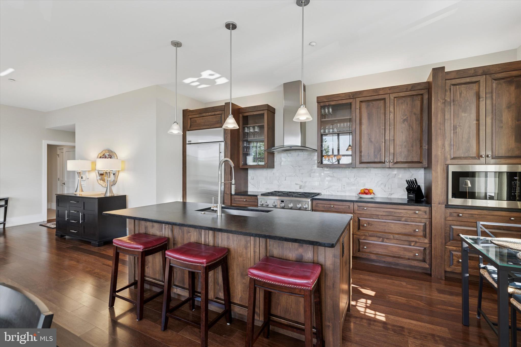 125 Iron Works Way Wayne, PA 19087 - Photo 13 of 32 a kitchen with granite countertop a stove a sink a dining table and chairs